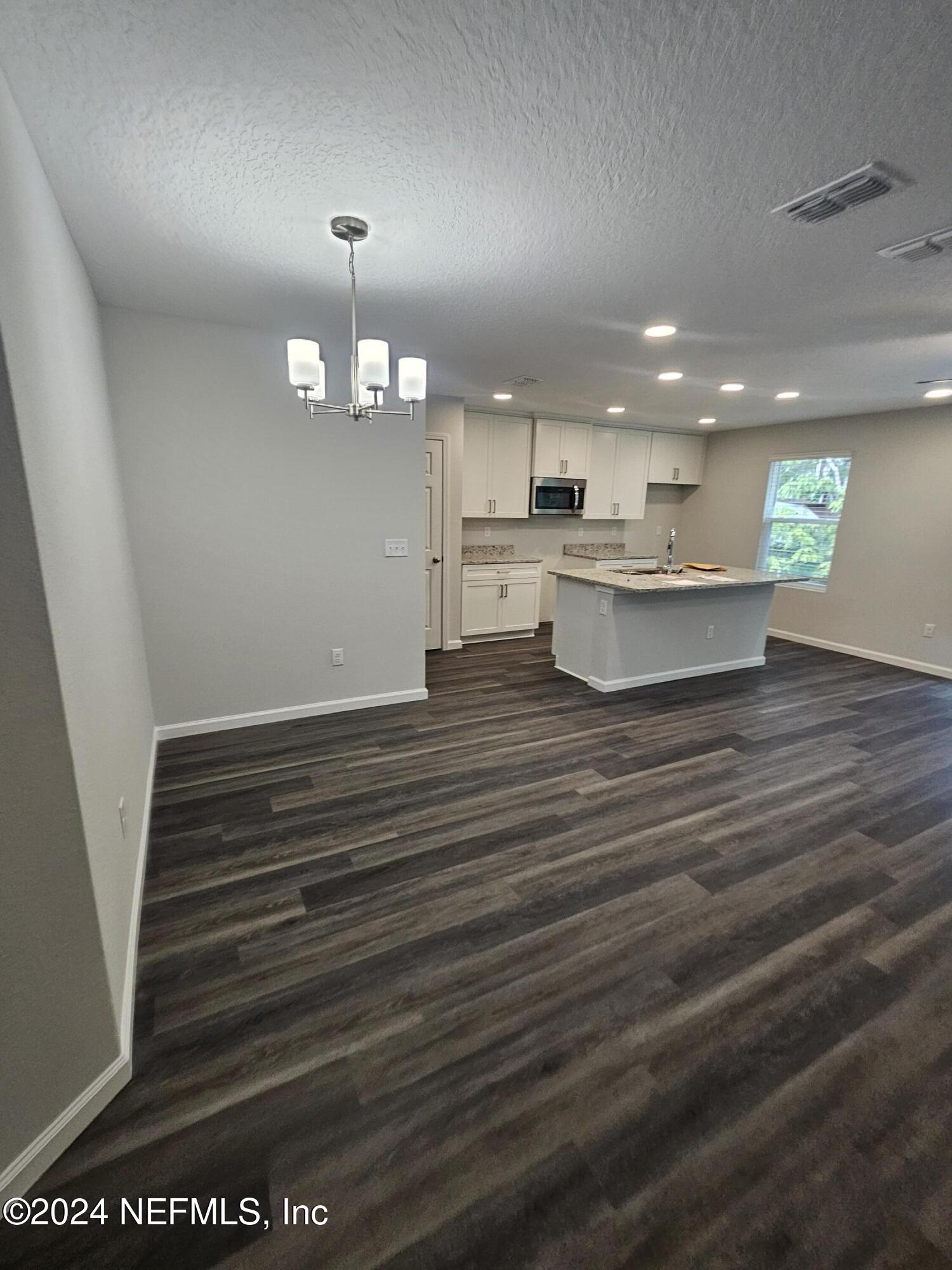 7607 Del Road Jacksonville, FL 32244 - Photo 6 of 15 a view of a kitchen with kitchen island white cabinets and wooden floor