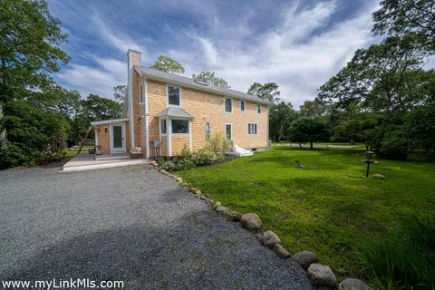 a front view of house with yard and green space