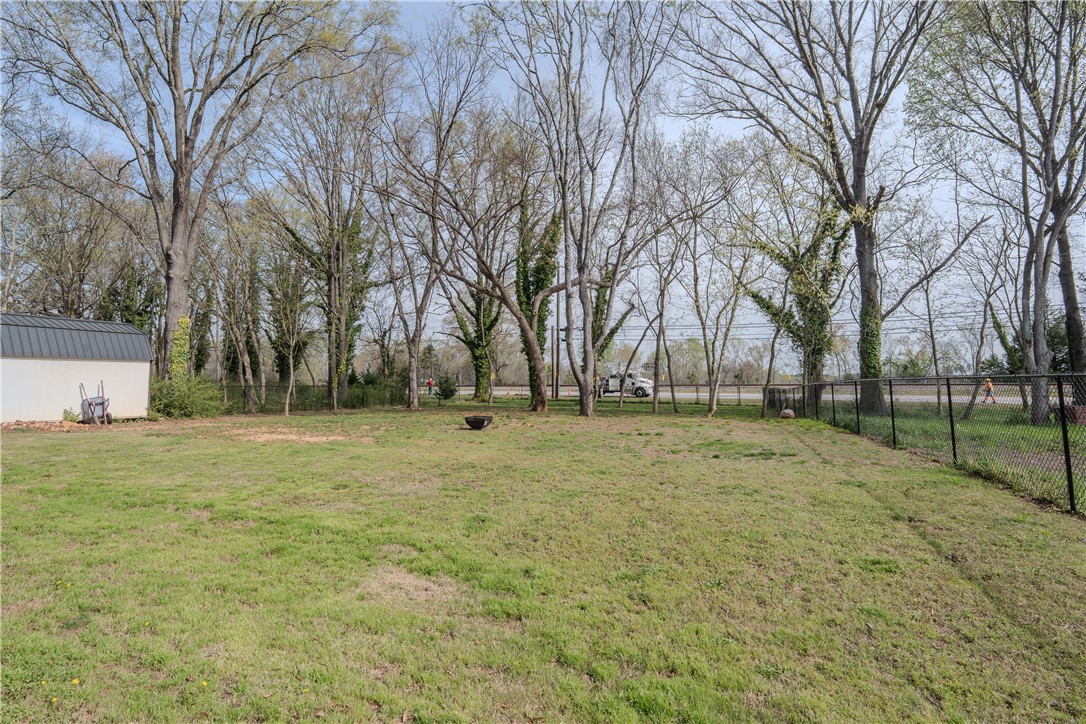 203 Mr Jim's Lane Clinton, SC 29325 - Photo 27 of 28 Expansive outdoor area with mature trees and a functional shed, perfect for leisure.