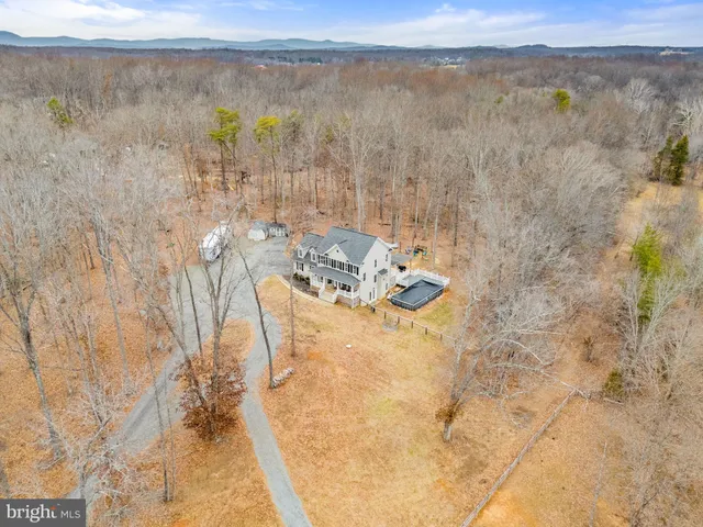 a kitchen with stainless steel appliances a dining table chairs refrigerator and microwave