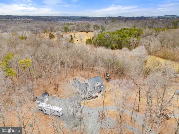 a kitchen with stainless steel appliances a stove top oven a sink dishwasher a refrigerator and a dining table with wooden floor