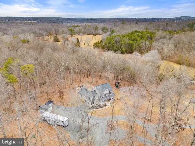 a kitchen with stainless steel appliances a stove top oven a sink dishwasher a refrigerator and a dining table with wooden floor