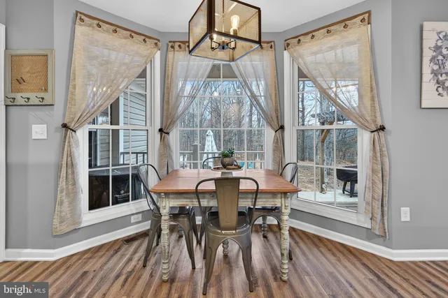 a view of a white house with large trees next to a road