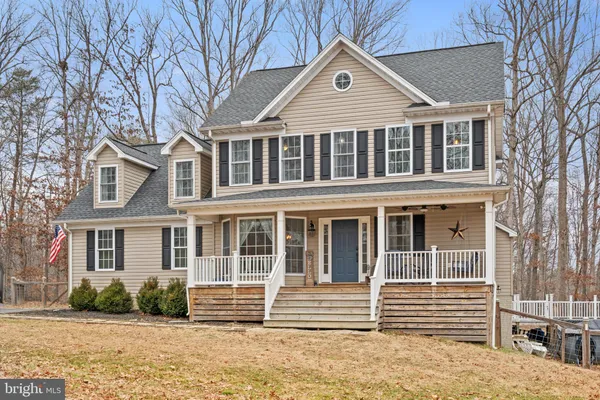 a front view of a house with a yard and lake view