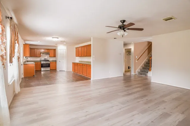 a large kitchen with stainless steel appliances granite countertop a stove a sink and a refrigerator