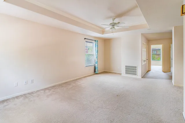an empty room with a ceiling fan and bathroom view
