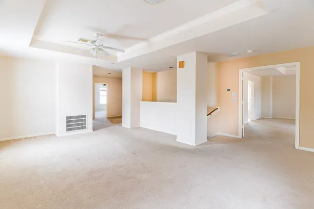 en empty room with windows and ceiling fan