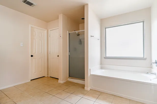 a spacious bathroom with a bathtub and a shower