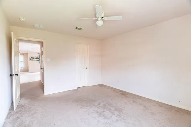 an empty room with windows and ceiling fan view