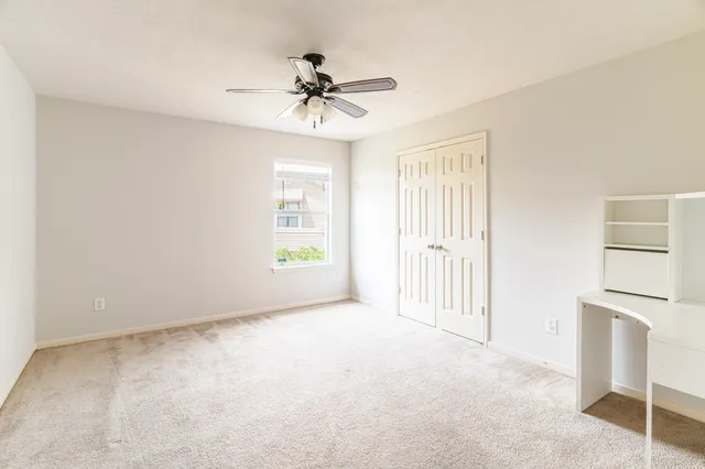 a view of empty room with a ceiling fan and window