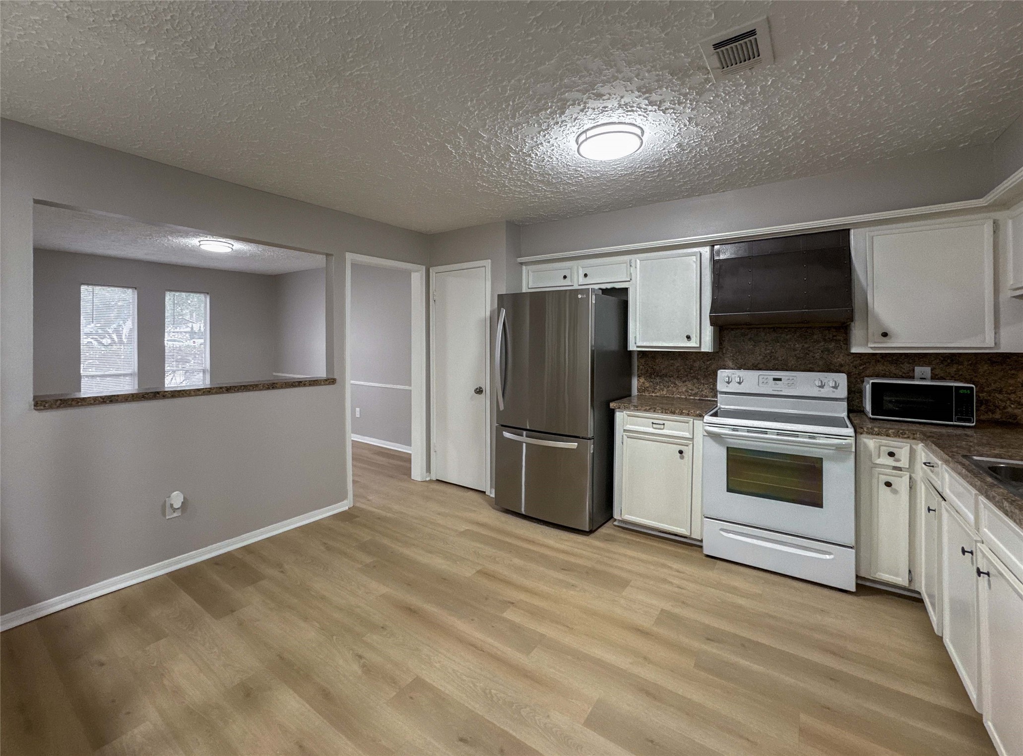22822 Canyon Lake Drive Spring, TX 77373 - Photo 7 of 26 a kitchen with stainless steel appliances kitchen island granite countertop a refrigerator stove and microwave