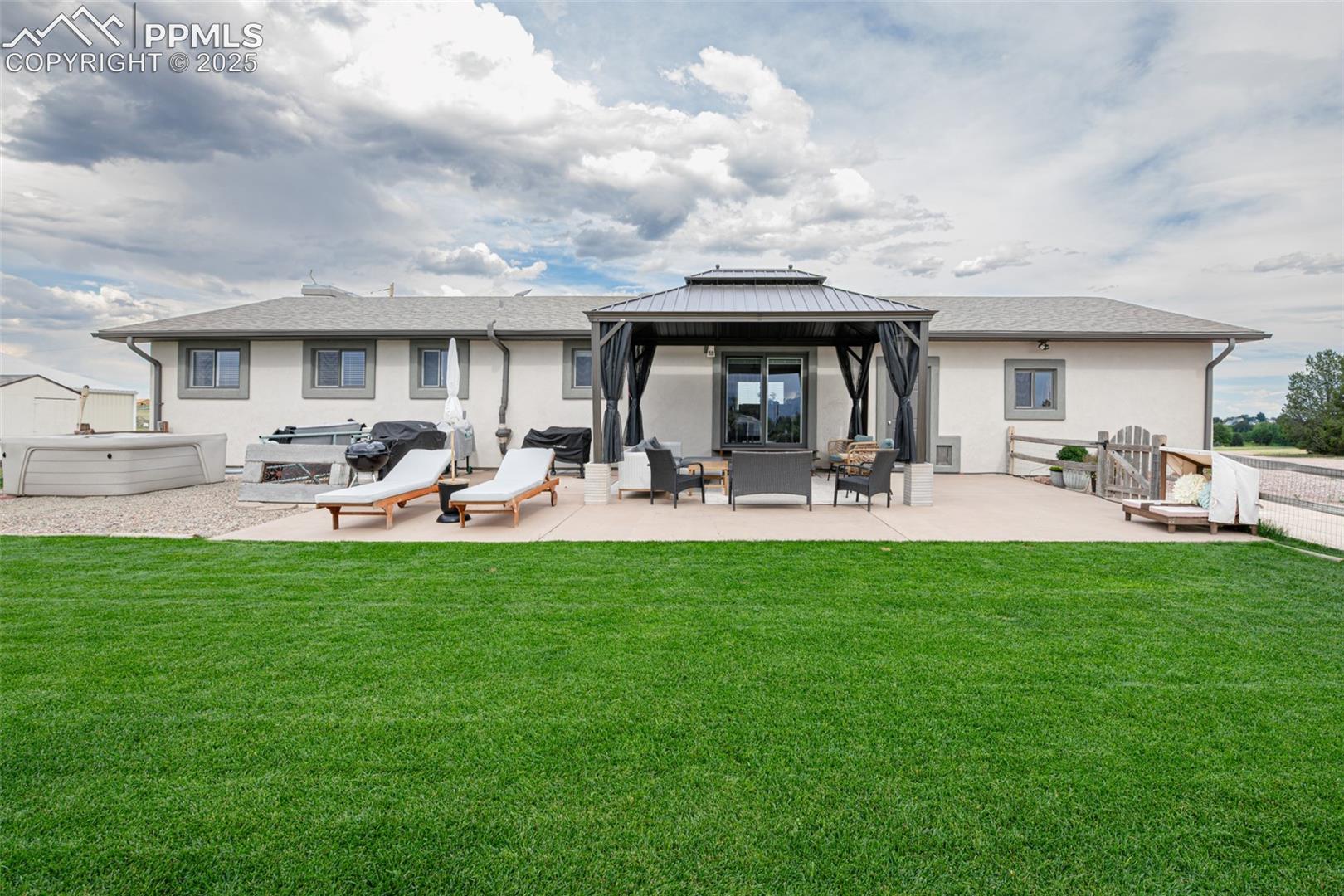 11170 Peaceful Valley Road Colorado Springs, CO 80925 - Photo 1 of 49 Back of property featuring a patio area, stucco siding, a gazebo, and a yard