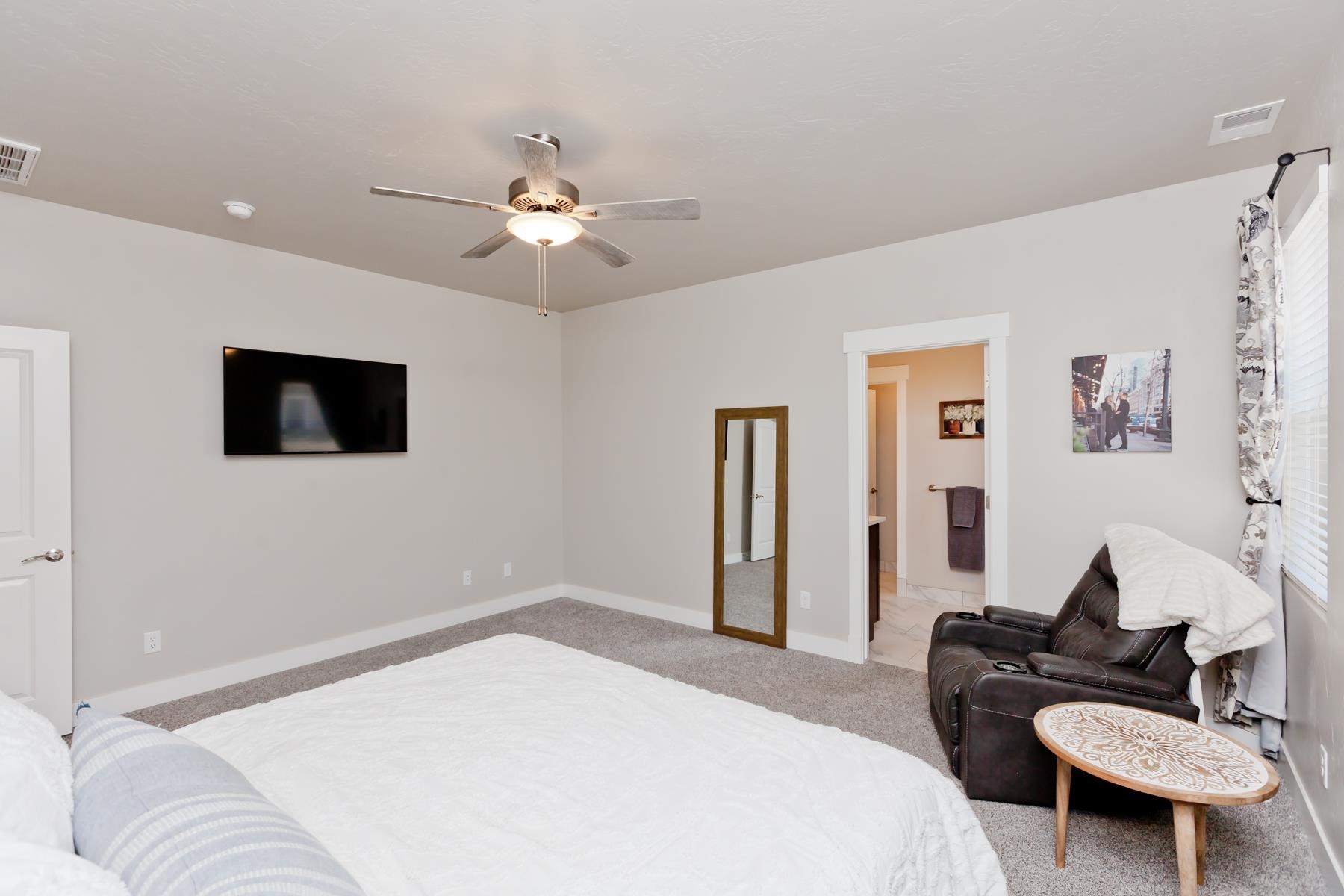 628 Thunder Ridge Drive Grand Junction, CO 81504 - Photo 15 of 37 a bedroom with a bed a couch and a flat screen tv