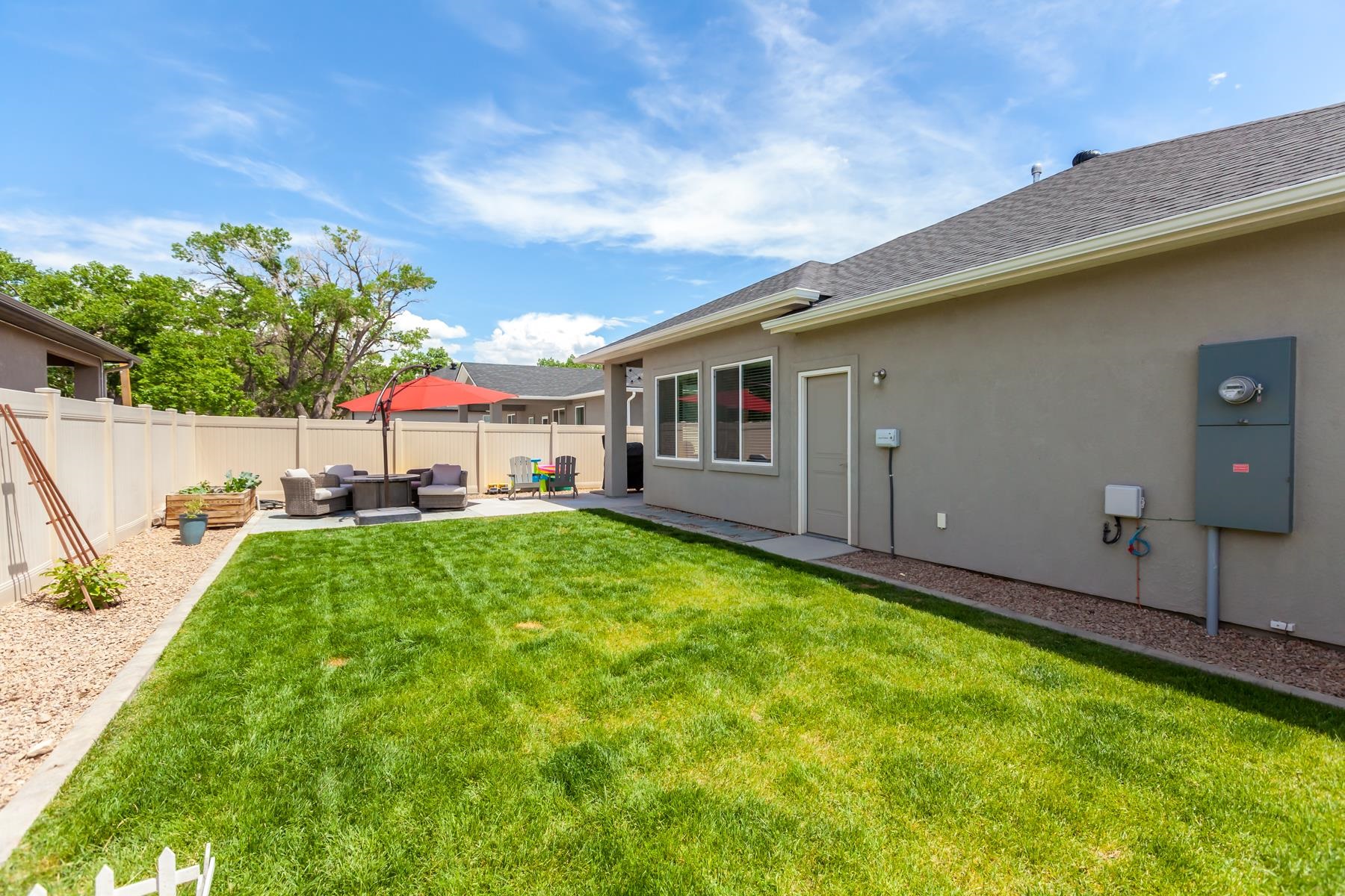 628 Thunder Ridge Drive Grand Junction, CO 81504 - Photo 30 of 37 a backyard of a house with table and chairs plants and large tree