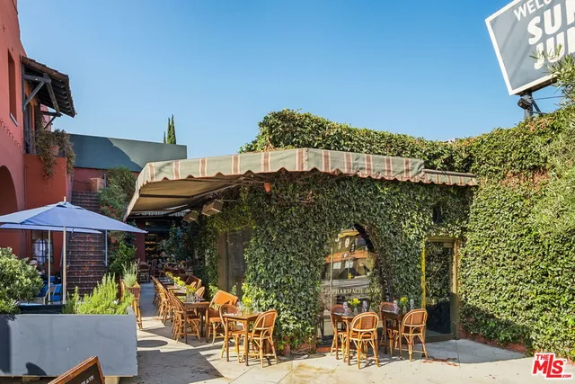 a view of a kitchen with an oven a dining table and chairs with wooden floor