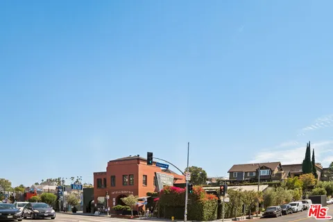 a front view of a building with cars parked