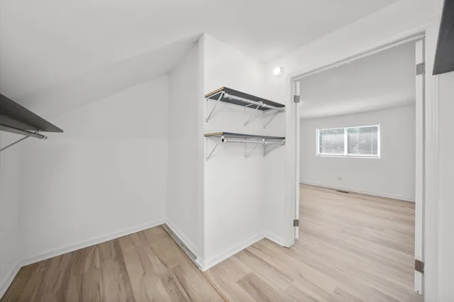 a view of a room with wooden floor and a ceiling fan