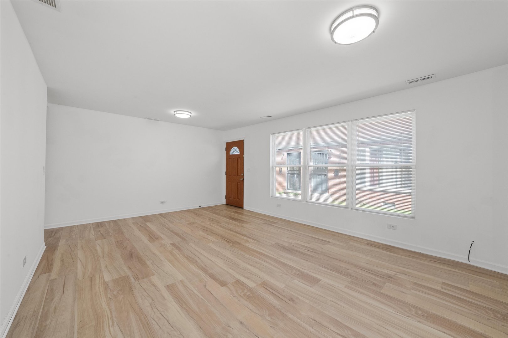 14732 Turner Avenue, Unit D Midlothian, IL 60445 - Photo 4 of 28 a view of an empty room with a window and wooden floor