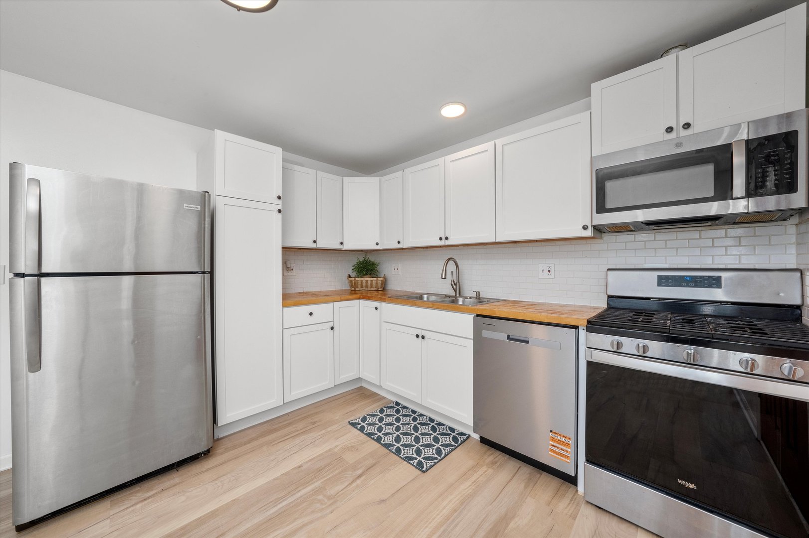 14732 Turner Avenue, Unit D Midlothian, IL 60445 - Photo 7 of 28 a kitchen with a refrigerator stove and white cabinets