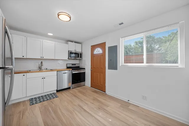 a kitchen with a refrigerator and a stove top oven