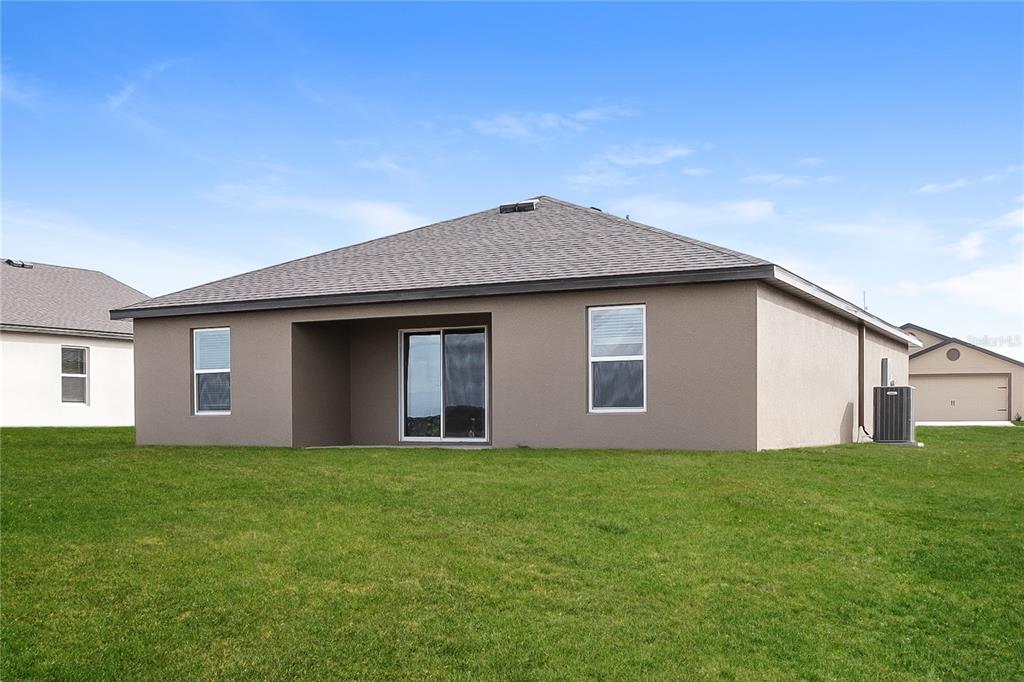 1724 Canaan Loop Dundee, FL 33838 - Photo 15 of 16 a front view of house with yard and trees in the background