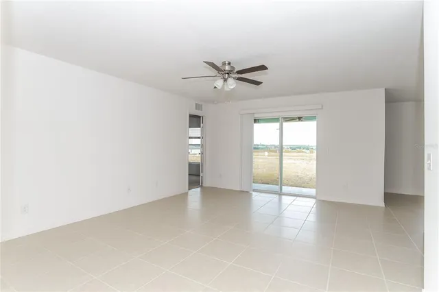 an empty room with fan and windows