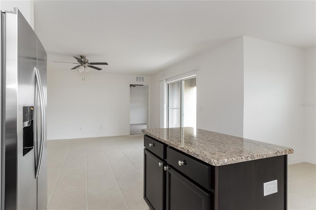 1724 Canaan Loop Dundee, FL 33838 - Photo 7 of 16 a kitchen with kitchen island a counter top space and a refrigerator