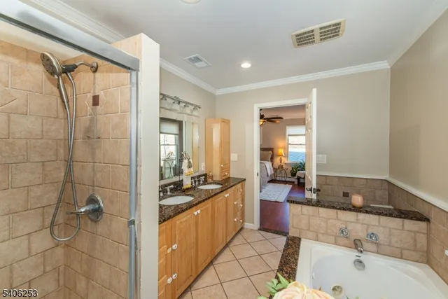 a bathroom with a granite countertop sink a mirror a bathtub and shower