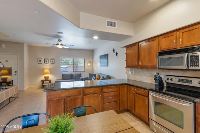 a kitchen with stainless steel appliances granite countertop a sink and a refrigerator