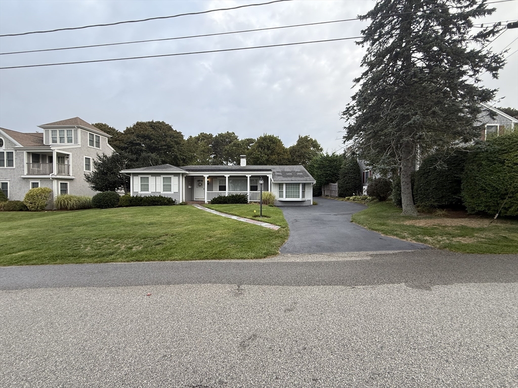 front view of house with a yard and potted plants