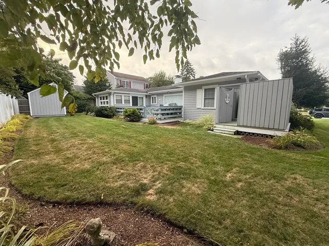 a view of a house with a large window and wooden fence