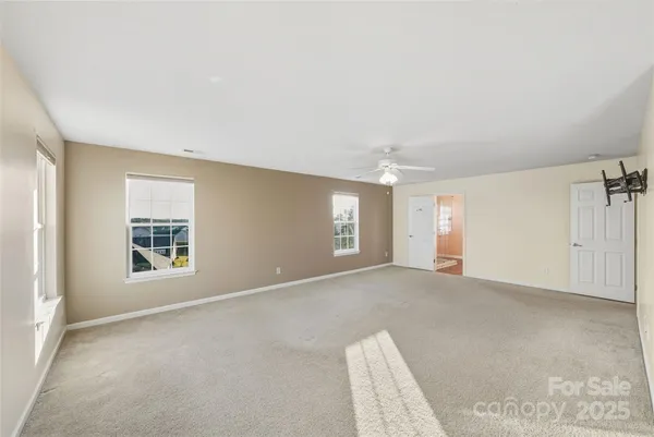 an empty room with a ceiling fan and a window