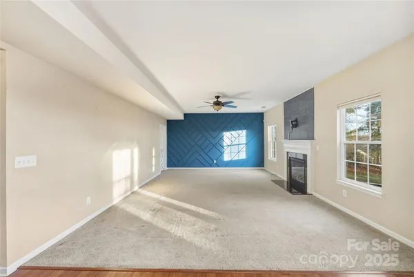 an empty room with windows and fireplace