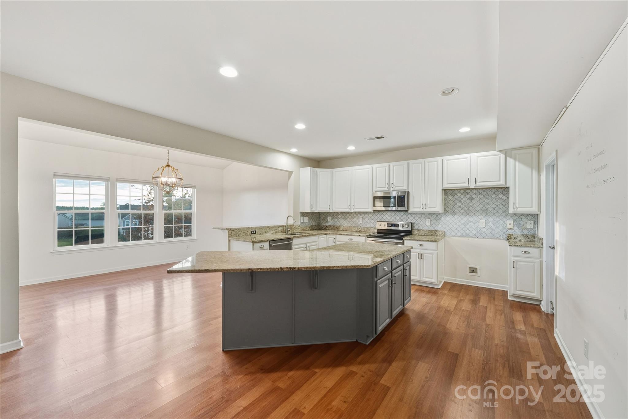 2155 Galloway Lane Southwest Concord, NC 28025 - Photo 7 of 40 a large kitchen with kitchen island a sink a center island and wooden floor