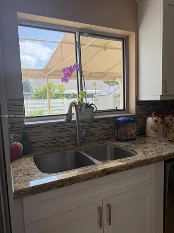 a kitchen with a sink a counter space and a window
