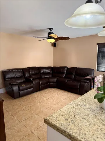 a black leather couch sitting in a kitchen with kitchen island