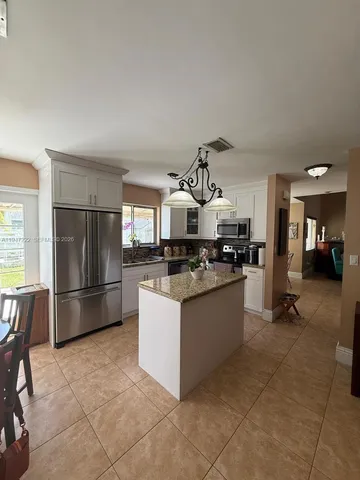 a kitchen with stainless steel appliances granite countertop a refrigerator and a stove