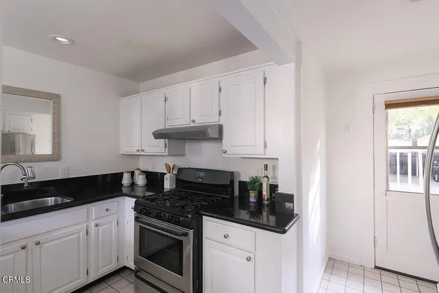 a kitchen with granite countertop white cabinets and appliances