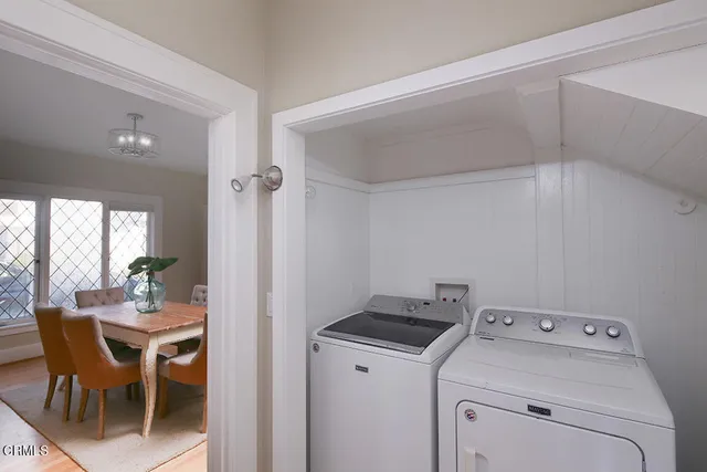 a view of washer and dryer with bathroom in the background