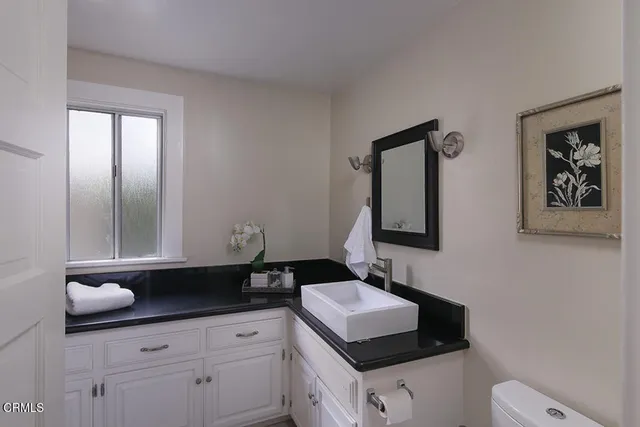 a bathroom with a toilet sink double vanity and mirror