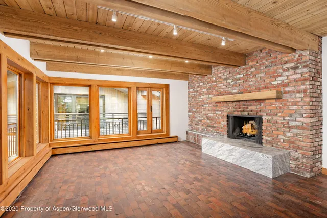 a view of an empty room with a fireplace and a window