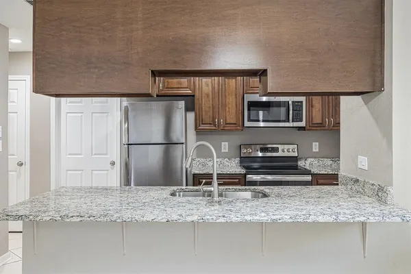 a kitchen with stainless steel appliances granite countertop a sink stove and refrigerator