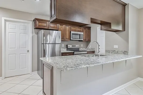 a kitchen with kitchen island a counter top space cabinets and stainless steel appliances