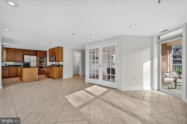 a open kitchen with cabinets and refrigerator