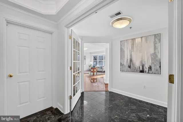 a view of a hallway to a livingroom with furniture and window