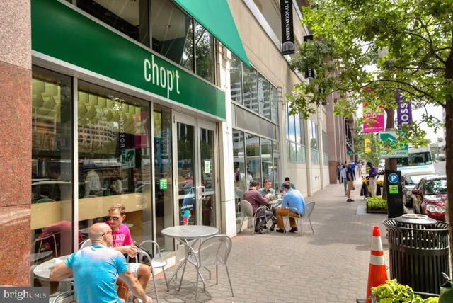 a group of people sitting in front of retail shop