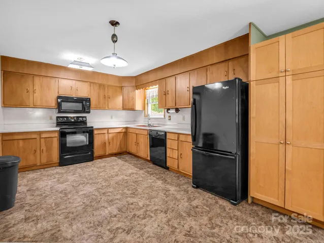 a kitchen with granite countertop a refrigerator and a stove top oven