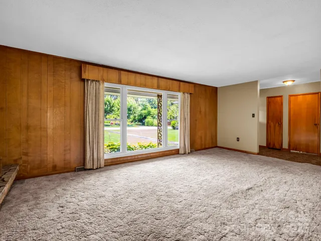 an empty room with large windows and view of room