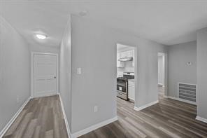 1227 Fair Drive Angleton, TX 77515 - Photo 18 of 18 a view of a hallway with wooden floor and a cabinet
