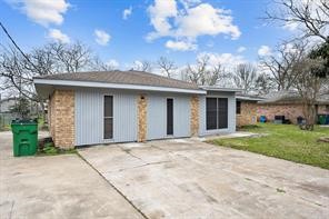 1227 Fair Drive Angleton, TX 77515 - Photo 2 of 18 a front view of a house with a garden and trees